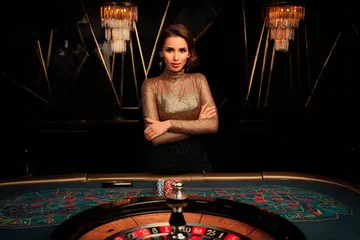 CROWNBD Slots — Thousands of thrilling machines await A woman smiling by bright slot machines showing lucky symbols, showcasing the exciting slot offerings at CROWNBD.